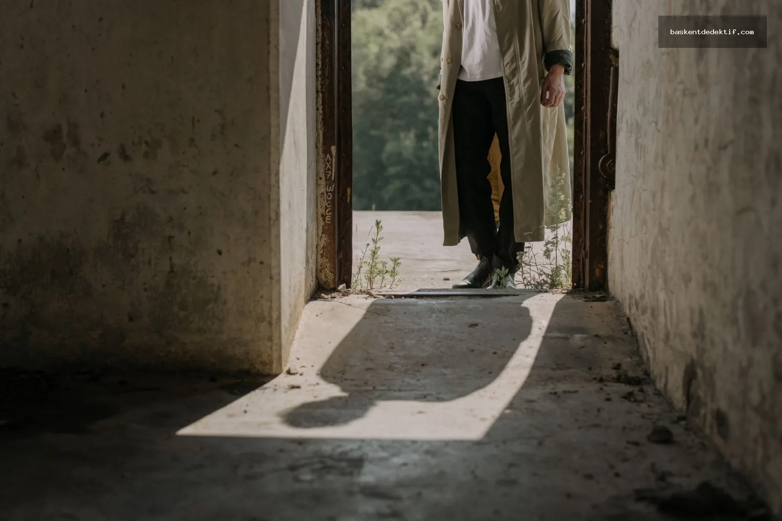 Mysterious detective in trench coat standing at shadowed Fethiye doorway with investigative