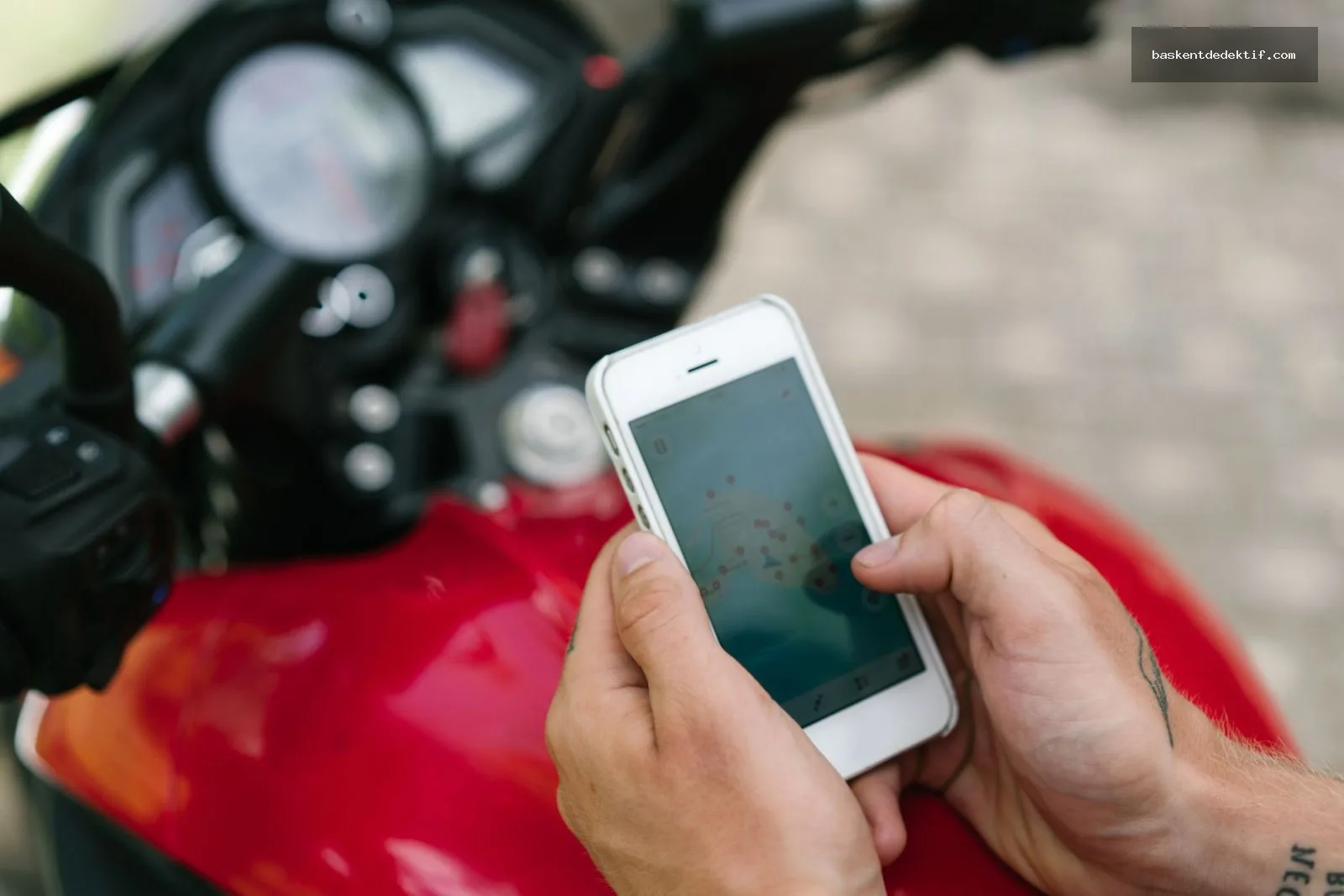 Motosiklet üzerinde harita uygulaması ile eş takibi yapan adam