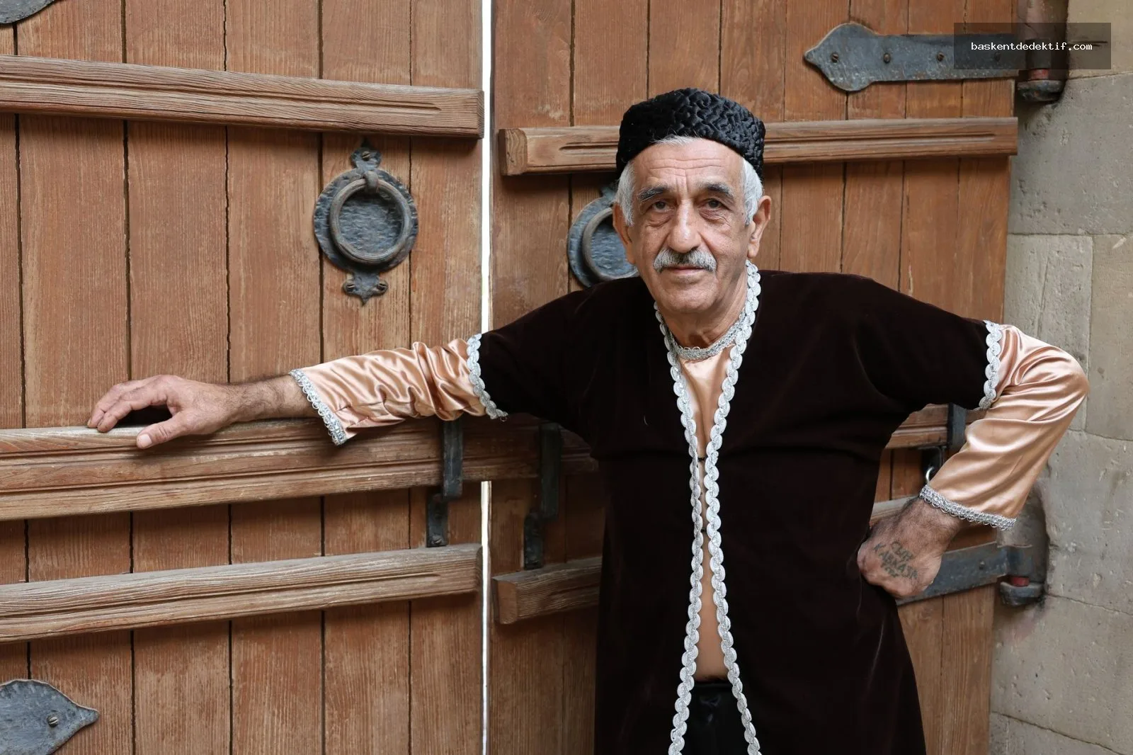 Selçuklu Dedektif kıyafetli yaşlı adam ahşap kapı başında