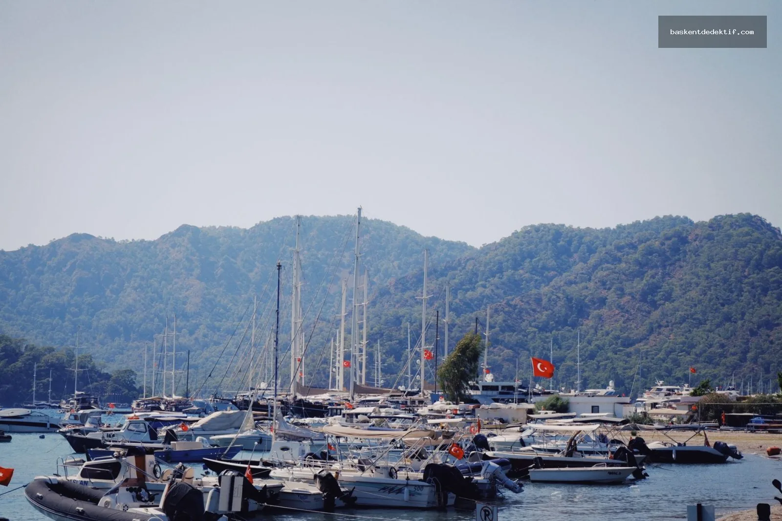 Kuşadası’nın deniz kenarında sakin bir deniz manzarası ve denizaltı gemileriyle dolu liman