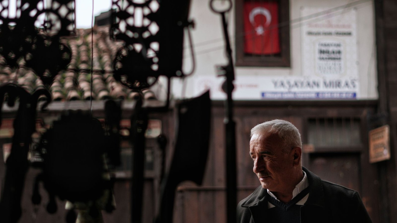Safranbolu Özel Dedektif Safranbolu'daki tarihi evler ve Türk bayrağı önünde yaşlı erkek